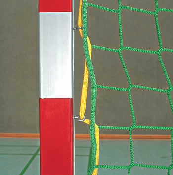 Nahaufnahme eines rot-weißen Handballtorpfostens mit grünem und gelbem Netz in einer Sporthalle