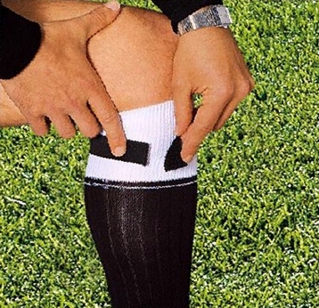 Person passt elastisches Sportband für besseren Halt an Socken an