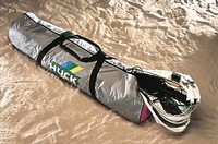 Eine robuste, graue Tragetasche mit schwarzen Griffen und einem Aufdruck, die auf sandigem Boden liegt, ideal für Outdoor-Abenteuer.