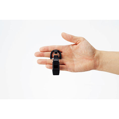 Eine Hand hält einen schwarzen Schlüsselanhänger mit Schnalle.