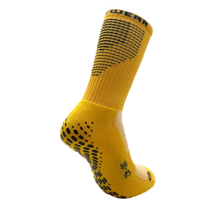 Un calzino giallo con puntini neri antiscivolo e motivo a maglia, ideale per le attività sportive.